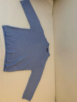 Ljusblå stickad tröja Lager 157 S men passar som storlek M - Mysig ljusblå stickad tröja från Lager 157 med rund halsringning och ribbade muddar. Tröjan har en enkel och clean design som passar perfekt till jeans eller kjol. Tillverkad i mjukt material som känns skönt mot huden.