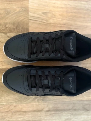 Reebok sneakers  - Snygga, svarta, låga sneakers från Reebok i storlek 38. Använda ett fåtal gånger och är i ett väldigt fint skick och passar till både träning och till vardags. 