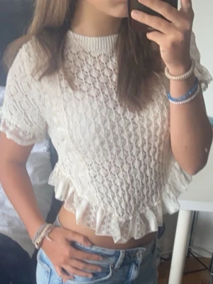 Cremevit spetsig croppad topp med volang - Söt cremevit croppad topp från Zara med spetsdetaljer och volangkant nertill. Använd 1 gång och inga defekter 💕