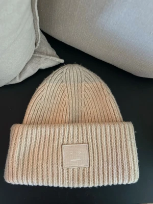 Beige ribbstickad mössa Acne Studios - Beige super fin acne mössa! Smink i fram men inget som syns när man använder den och går säkert bort om man tvättar🌸skriv egna prisförslag 