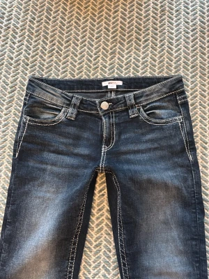 Mörkblå jeans med detaljerad ficka - Säljer dessa mörkblå jeans med detaljer på bakfickorna, från Gina 14+. Använd ett fåtal gånger, då de är lite stora för mig. Nypris är 399kr Innerbenslängd: 78cm                                                         Midja: 68cm                                                                          Stuss: 93cm