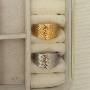 3 för 2 på alla ringar  - Säljer två bred ring i guldfärg och silverfärgad med hamrad, ojämn yta som ger en cool och unik look. Ringen har en modern och chunky design som sticker ut och passar perfekt för dig som gillar statement-smycken.