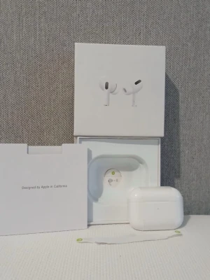 Apple AirPods Pro med laddningsetui - Säljer ett par Apple AirPods Pro med vitt laddningsetui. Hörlurarna är trådlösa in-ear-modell och levereras i originalförpackning med tillbehör.1.1  Klassisk Apple-design i blank vit plast och kompakt format. Perfekt för musik, samtal och träning.