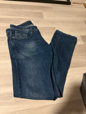 Blå raka jeans från Replay - Säljer ett par klassiska blå jeans från Replay med raka ben. Jeansen har en snygg tvätt med lätt slitning och detaljerad bakficka. Perfekta för en avslappnad och stilren look. Hör av er vid intresse!✨