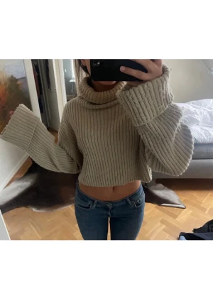 Beige croppad polotröja stickad - Säljer en beige croppad stickad polotröja med breda ärmar och ribbad struktur. Jag säljer pga att den inte satt så som jag trodde att den skulle. Bild är från tidigare säljare 
