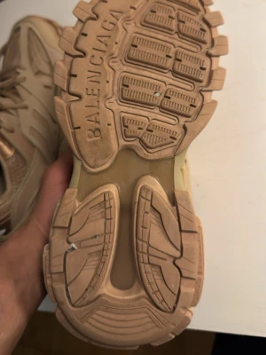 Beige Balenciaga Track sneakers - Säljer ett par beige Balenciaga Track sneakers med chunky sula och detaljer i mesh och syntet. Skorna har flera lager och coola paneler, samt Balenciaga-logga under sulan. Perfekta för dig som gillar statement sneakers och streetwear vibes.