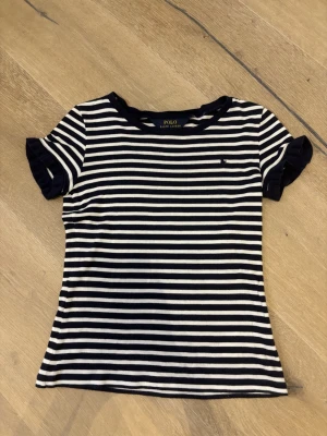 Randig t-shirt från Polo Ralph Lauren - Säljer denna mörkblå och vit randiga polo ralph lauren t-shirten❣️