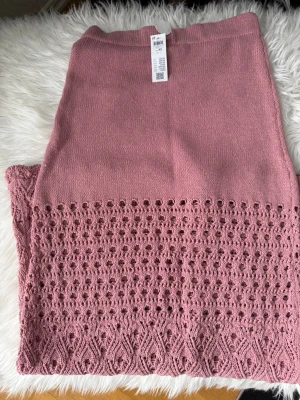 Rosa stickad långkjol med spetsdetaljer - Supersnygg rosa långkjol med stickad struktur och vackra spetsdetaljer nedtill.