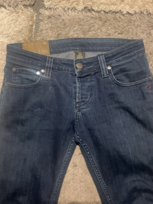 Mörkblå jeans från Denham - Hallå elle! Säljer ett par riktigt feta dondup jeans med den klassiska femficksmodell och snygga kontrastsömmar. Jeansen har en slim/skinny passform och är i w28 men står som w30, samt har de en liten röd söm på myntfickan. Perfekta för en stilren grischoutfit.