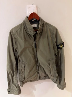 Stone Island Jacka - Säljer nu denna snygga vårjacka i militärgrön färg. Av modellen Microreps, i den gamla modellen från Stone Island som ej säljs längre, mycket sällsynt!  Storleken är L, men passar en S/M.  Köpt i vintage butik i London, box ink. Först till kvarn, passa på!