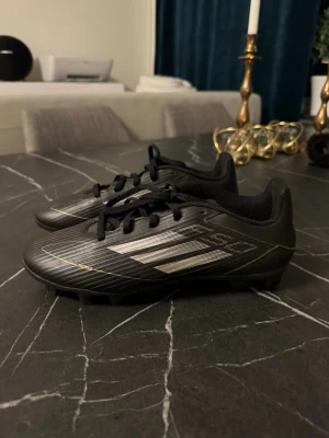 Adidas F50 League Fotbollsskor - Hej! Säljer ett par helt nya Adidas F50 League Fotbollsskor i storlek 40. Dom är helt nya och är i nyskick och de passar inte och behöver bli av med dom. Sulan har fasta dobbar och tillverkade i syntetmaterial. Köptes på Boozt, köptes för 699kr och säljer för 250kr. 