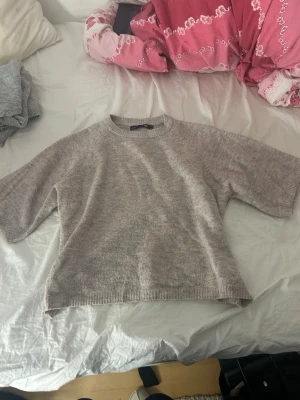 Beige stickad tröja från 157 - Mysig beige stickad tröja från lager 157 med rund halsringning och avslappnad passform. Tröjan har halvlånga ärmar och ribbade kanter vid hals, ärmslut och nederkant. Perfekt för lager på lager och enkel att matcha med jeans eller kjol. Flitig använd och lite större i modellen skulle jag säga men väldigt fin!
