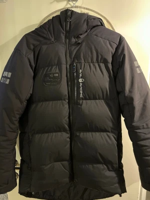 Svart Sail Racing Jacka - Säljer min svarta Sail Racing Antarctica jacka i storlek S. Skicket är på topp – inga fläckar, hål eller skador. Väldigt sparsamt använd. En riktigt varm och stilren vinterjacka med snygga detaljer och loggor både fram och bak. Rejäl kvalitet och perfekt passform. Pris kan diskuteras dm jackan passar även M.