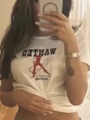 Vit t-shirt med cowboy-tryck - Vit t-shirt med svart text 'WANTED' och ett rött cowboy-motiv på bröstet. Under motivet står det 'RODEO GIRL REWARD 2005'. T-shirten har rund hals och korta ärmar, tillverkad i mjuk bomull. Perfekt för en avslappnad och cool stil.Stolek L men är väldigt liten i storlek passar mig som har XS🩷Andvänd 1 gång. 