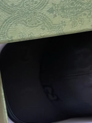 Svart keps från GG med GG-mönster - Snygg svart keps från GG med det klassiska GG-monogrammet över hela kepsen. Kepsen har böjd skärm och är tillverkad i ett slitstarkt tyg med läderdetaljer längs kanten på skärmen. Perfekt för dig som gillar exklusiva accessoarer.