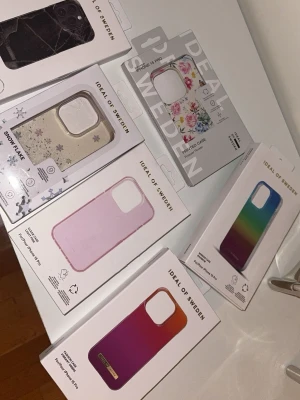 Ideal of sweden skal - Säljer flera skal från iDeal of Sweden till iPhone 15 Pro. Små små ytliga repor som mest syns om man lyser på de svarta, blommiga och ombre skalen. Även på ombre skalet är det en liten skada som jag har tagit bild på på andra bilden. Skalen som i princip aldrig är använda är den i regnbågs färg, snöflingor och ljus rosa genomskinliga. 100kr/st eller 450 för alla