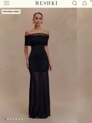 Svart offshoulder långklänning Meshki - Pris går att diskutera!!!! Säljer denna eleganta svarta långklänningen från Meshki med offshoulder-design och transparent nederdel. Den är helt oanvänd och har lappen kvar. Klänningen har rynkade detaljer över midjan och höfterna, vilket ger en snygg siluett. Materialet är polyester och klänningen är perfekt för dig som vill sticka ut. Super fin på!! 