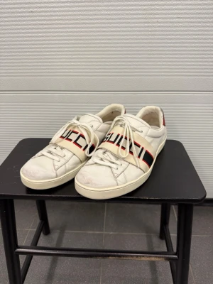 Gucci Ace logo skor  - Ett par snygga vita Gucci ace sneakers fint använt skick! Storlek UK8 motsvarar 43. Nypris 7000kr självklart äkta. Hör av er vid frågor! 