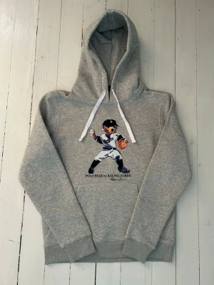 Ralph Lauren polo bear hoodie herr, storlek S - Hej! Säljer denna riktigt schyssta polo bear hoodie från Ralph Lauren. Den är i storlek M men sitter en storlek litet och passar därför som en S. Den är endast använd någon enstaka gång och är därmed i ett nyskick. Original lappar och påse finns kvar och medföljer naturligtvis vid köp. Jag fraktar alltid snabbt!  Mvh