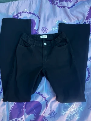 Svarta bootcut jeans från Lindex  - Säljer ett par svarta bootcut jeans från Lindex. Jeansen har klassisk femficksdesign, hög midja och utsvängda ben. Materialet är mjukt och stretchigt för extra komfort. Perfekta för dig som vill ha en snygg och enkel bas i garderoben.