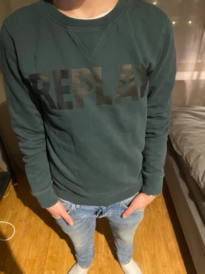 Mörkgrön sweatshirt från Replay - Snygg mörkgrön sweatshirt från Replay med stor svart logga över bröstet. Tröjan har rund halsringning och långa ärmar. Perfekt till jeans för en avslappnad och trendig look.