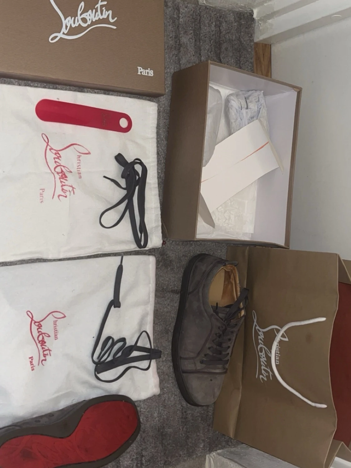 Gråa Louboutin sneakers med röd sula