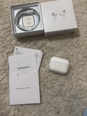 Apple AirPods Pro med laddningsetui - Säljer ett par vita Apple AirPods Pro med trådlöst laddningsetui. Kommer med originalkartong, laddningskabel och manualer.  1:1