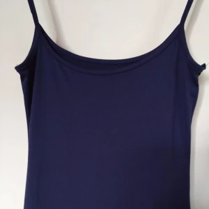 Lång marinblå klänning - Jag säljer en super fin lång marinblå klänning med smala axelband och stretchigt material🌟, jag är 168cm och klänningen når till nästan precis början av mina fötter.