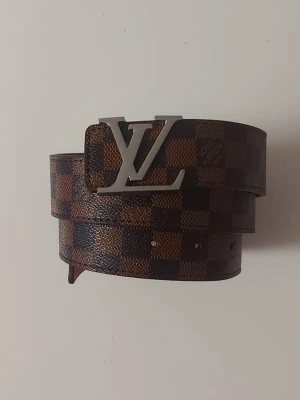 L bälte brunt  - Helt nytt brunt bälte. Aldrig använt, i perfekt skick. Längd: 105 cm. Klassisk design, se bilder för detaljer.