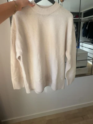 Beige stickad tröja från Soaked in Luxury - Snygg vårig beige stickad tröja från Soaked in Luxury. 70% ull. Tröjan har en hög ribbad krage, ribbade muddar vid ärmarna. Helt oanvänd, pris kan diskuteras.