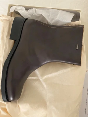 Our legacy camion boots - Snygga bruna boots från our legacy i slätt läder med minimalistisk design och fyrkantig tå. Skon har en robust klack och dragkedja på insidan. Perfekt för dig som gillar stilrena boots med modern känsla.