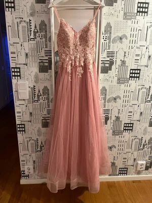 Balklänning - Balklänning från jjs house i storlek 34. Färgen ”blush” Storleksmåtten enligt jjshouse är: Byst- 83cm, midja- 65cm, höfter- 91cm, halsgrop till nedre fåll(framsida)- 147cm. Den är lite smutsig längst ner då den släpade i marken, det är inte synligt och jag kan inte få med de på bild🥲