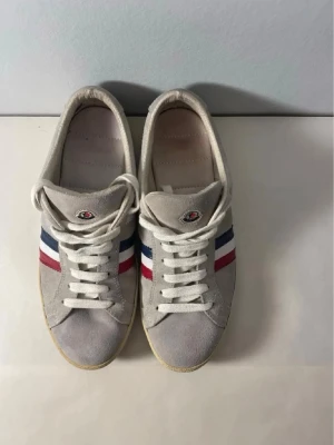 Äkta MONCLER SKOR - hej! Säljer mina eftertraktade Moncler skor perfekt till våren!      Stilrena och passar till varje outfit!     ny pris=5000kr.    Mitt pris= 1299kr    Modellen heter ”Monaco2”.         OBS sulan har släppt lite på vänster sko på tån. Och de är slitna på sidan