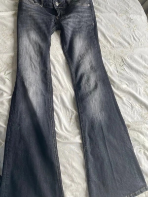 Mörkgrå låg midjade jeans - tall - Säljer ett par populära mörkgrå lågmidjade bootcut jeans från Lager. Jeansen är perfekta för dig som gillar en avslappnad men trendig look. Defekter : väldigt minimala, inget jag kunde se på byxan. Använda 3 gånger. 