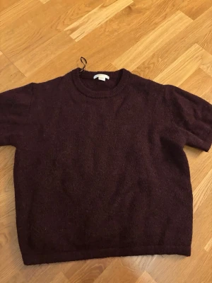 Mörklila stickad tröja Gina Tricot - Mysig vinröd stickad tröja från Gina Tricot. Perfekt för kyliga dagar och enkel att matcha med jeans eller kjol. Nyskick