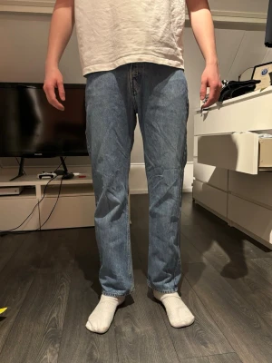 Blå raka jeans i klassisk modell weekday  - Säljer ett par blå jeans med rak passform och normal midja. Jeansen har fem fickor och klassisk denimlook. Perfekta för dig som gillar en enkel och tidlös stil. Materialet är bomullsdenim och färgen är mellanblå.