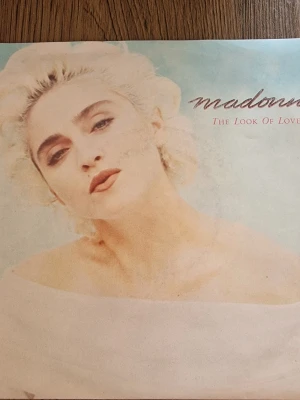 Madonna The Look Of Love vinylsingel - Säljer en vinylsingel med Madonna – The Look Of Love. Omslaget har ett porträtt i ljusa färger och låtarna är The Look Of Love och I Know It. Släppt av Sire Records 1987. Perfekt för samlare av popmusik och Madonna-relaterade prylar.
