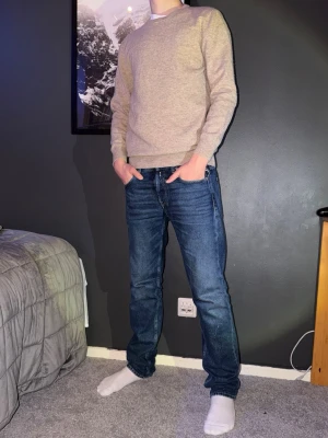 Beige stickad tröja från Garde Grisch - Säljer en stilren beige stickad tröja från Garde Grisch i storlek XS. Tröjan har rund halsringning, ribbade muddar och en klassisk passform. Går att köpa med jeans för bättre pris. Personen på bilden är 177