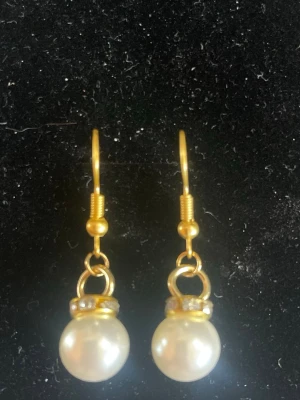 Guldörhängen med vita pärlor - Snygga örhängen med guldfärgade krokar och vita pärlor.Perfekta för dig som gillar elegant och tidlös stil.