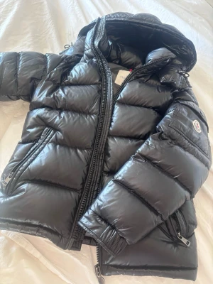 Moncler Maya äkta  - Säljer nu min Moncler Maya i storlek 00 vilket motsvarar xs. Det är den klassiska herrmodellen Maya som kostar 18 000 i nypris.  Jackan är i sjukt fint skick inga slitningar den ser helt ny ut. Jackan är köpt i Moncler butiken i stan perfekt om man vill ha en exklusiv jacka men inte betala nypris .