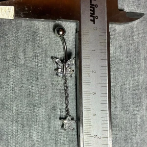 ✨ NY oanvänd navelpiercing med hänge - Kirurgiskt stål 316L  - ✨ NYTT oanvänt smycke i kirurgiskt stål! 🌸 Hållbart & Rostfritt: Slitstarkt 316L-stål som inte oxiderar eller rostar av fukt. 🌸 Säkert: Industristandard, skonsamt för läkta piercingar.  🛍️ 30 % BUNDLE-RABATT! Köp fler artiklar från min shop och få 30 % på allt! ✨ 📦 Frakt: Endast spårbart via Plick SafePay för vår trygghet.