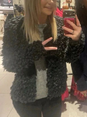 Svart fluffig teddyjacka - Säljer en svart teddyjacka/ kofta från Kappahl. Ärvde från min mamma så den är rätt så gammal men ändå väldigt fint skick. 
