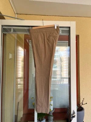 Banana Republic: beige byxor storlek 2 - Beige byxor från Banana Republic, modell Sloan. Byxorna har en klassisk design med figurnära passform. Material viskos, bomull och elestan. Stretch. Motsvarar stl.32/34.