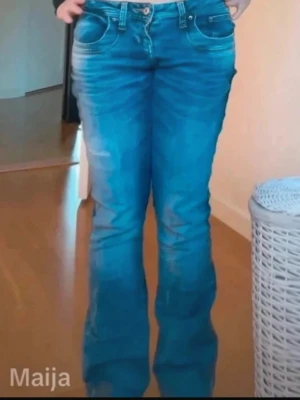 Blå bootcut jeans med slitningar - Midjemått: 37 cm, innerbenslängd: 76,5 cm 