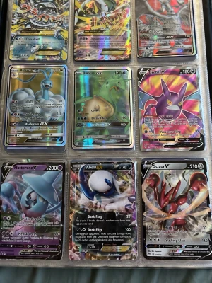 Samling Pokémon GX och V kort - Stor samling Pokémon GX och V samlarkort med färgstarka och holografiska motiv. Kort med populära Pokémon som Crobat, Lapras, Hatterene, Absol, Scizor, Ampharos, Venusaur och fler. Korten är av plast och har klassisk rektangulär form, perfekta för samlare och Pokémon-fans. Pokémon kort samling