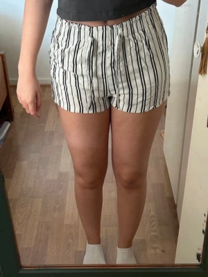 Barn-shorts - Vita shorts för barn med svarta ränder. Två framfickor. Resår i midjan med knytband. Från H&M i fint skick. Storlek: EUR 158/164 Material: Viskos