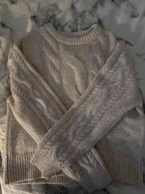 Beige kabelstickad tröja från Gina Tricot 💕 - Mysig beige kabelstickad tröja med rund halsringning och breda ribbade muddar vid ärmslut och nederkant. Tröjan har ett klassiskt flätmönster både fram och på ärmarna. Perfekt för lager på lager under kyliga dagar. Tröjan är i inte alls mycket använd och kommer från Gina Young 💗Kan skicka mer och bättre bilder om det önskas 😇💕