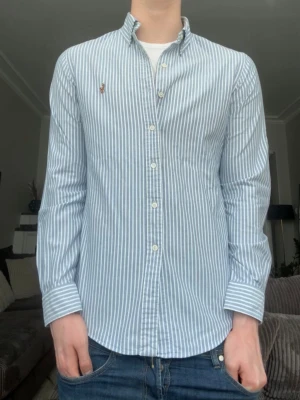 Ralph lauren skjorta randig Slim fit - Riktigt snygg slim fit ralph lauren skjorta i storlek S. Modellen på bilden är 186 cm och 72 kg. Riktigt snygg och stilren nu till sommarn. Hör gärna av er vis funderingar mvh Ae💯Riktigt jävla bra skick på denna skjorta. Alla paket skickas samma dag ni köper
