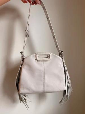 Vit axelväska med fransar från maje - Superfin väska från maje i modellen miss mini crinkled. Väldigg fint skick och nypris 4095. Ge gärna prisförslag! 💓