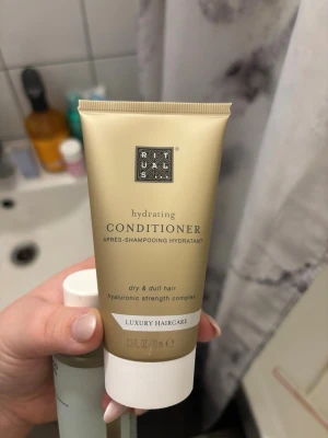 Rituals hydrating conditioner 70 ml - Lyxig återfuktande balsam från Rituals för torrt och livlöst hår. Innehåller hyaluronic strength complex som ger extra fukt och styrka. Tuben är guld- och vitfärgad med elegant design och rymmer 70 ml.